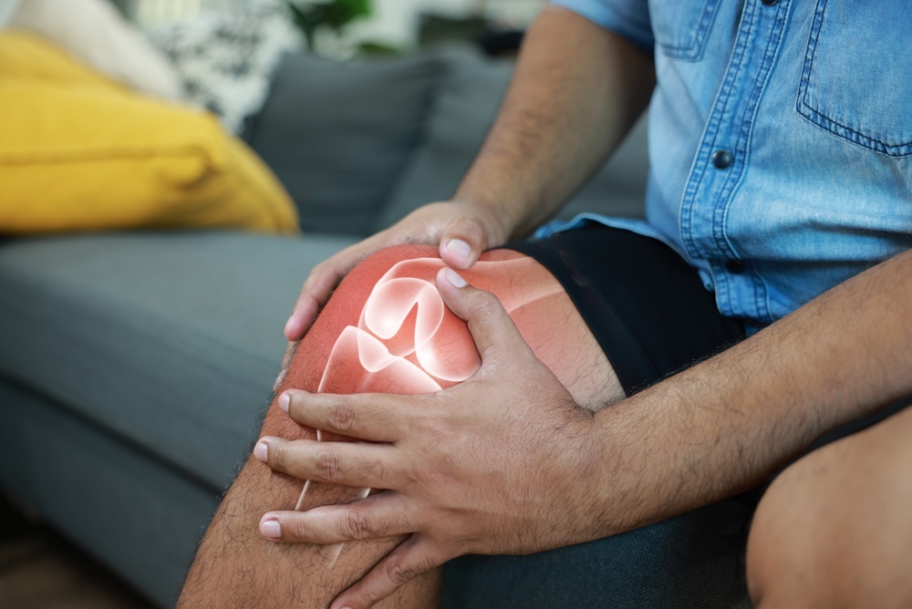 Close-up,Of,Hand,Holding,Painful,Injured,Knee,With,Red,Inflamed