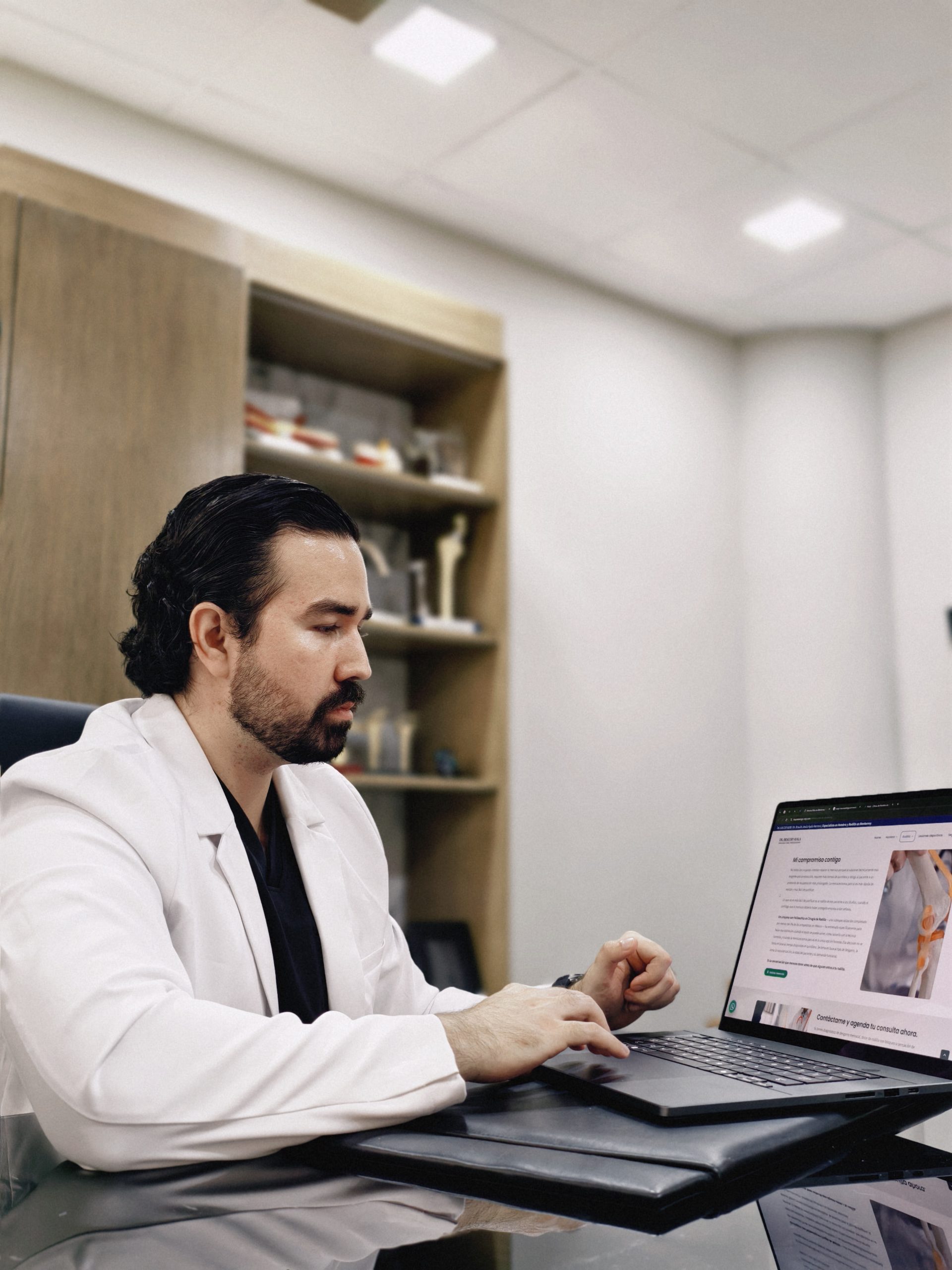 Dr. Braulio Ayala trabajando en su consultorio de Doctors Hospital, Monterrey, junto a modelos anatómicos