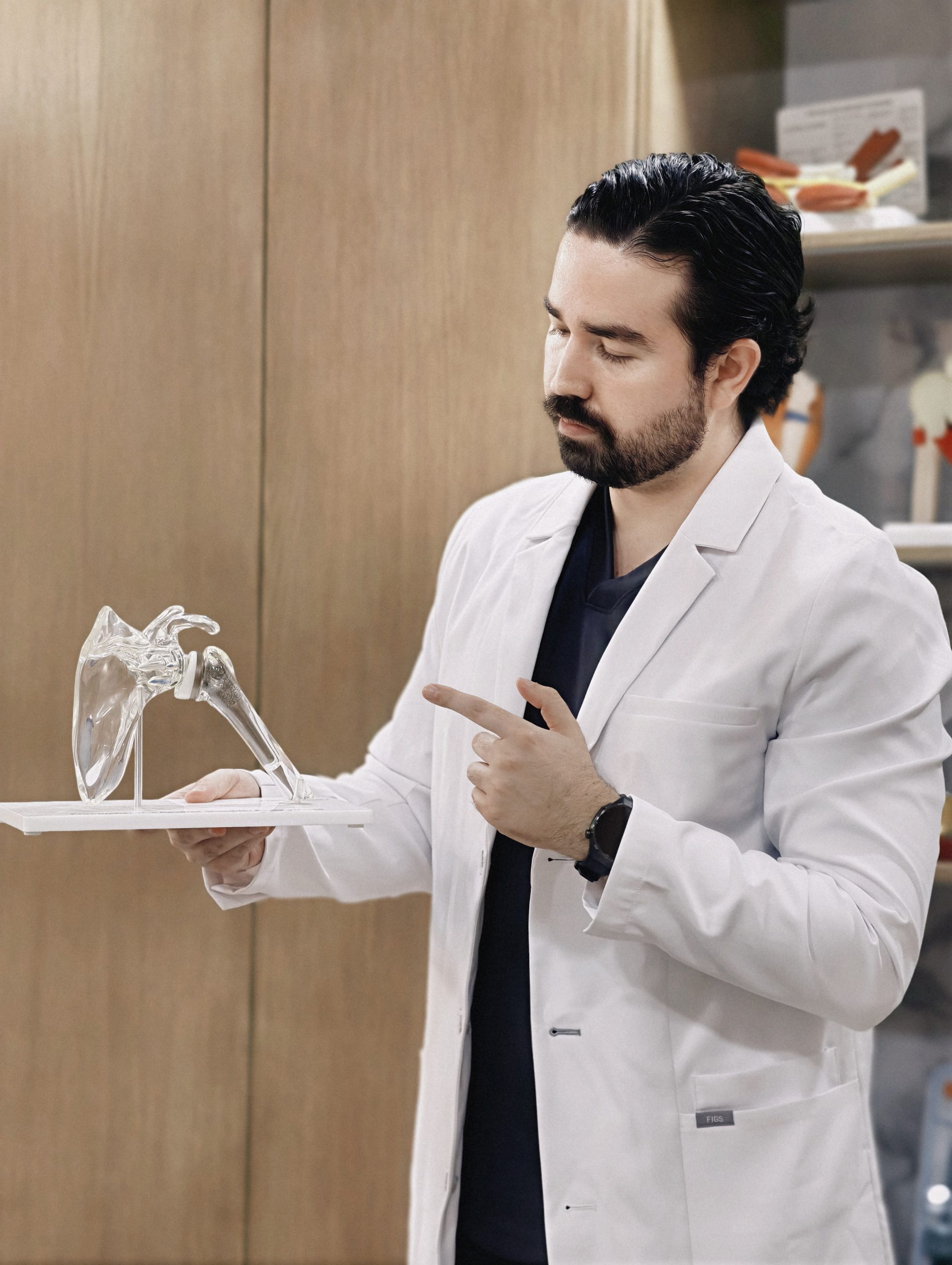 Dr. Braulio Ayala señalando un modelo anatómico de hombro durante una valoración en Monterrey