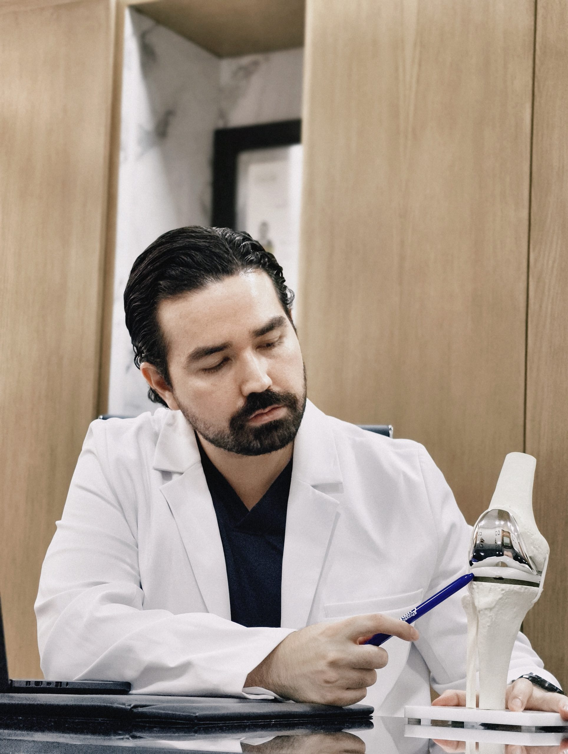 Dr. Braulio Ayala explicando un modelo de implante de rodilla a un paciente en Monterrey